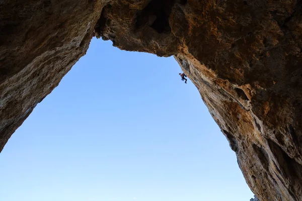 Junger Mann klettert an Felsen entlang — Stockfoto