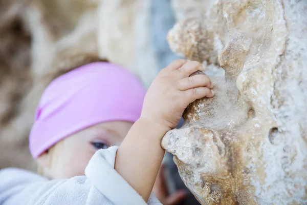 Little girl gripping cliff — Stock Photo, Image