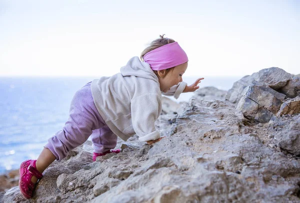 快乐的小女孩爬上岩石 — 图库照片