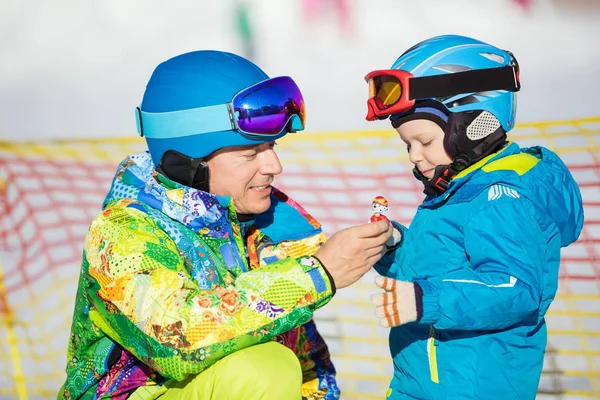 Far och Lille son i skidåkning kläder leker med leksak — Stockfoto