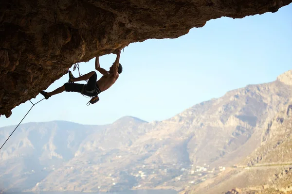 Jeune homme essayant d'atteindre la falaise afin de continuer l'escalade — Photo