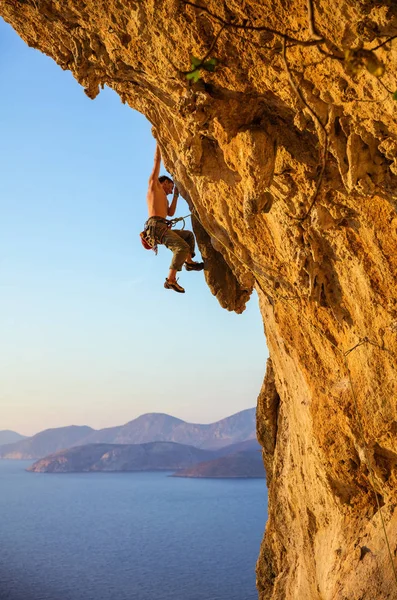 Jeune homme essayant d'atteindre la falaise afin de continuer l'escalade — Photo