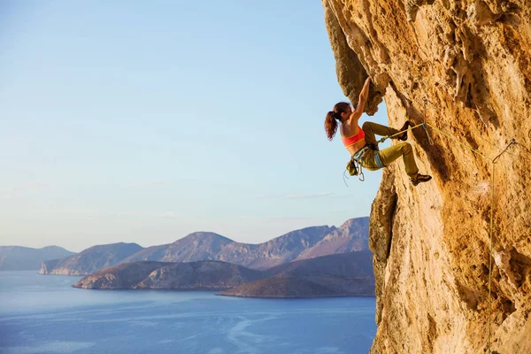 Escalade féminine sur un parcours difficile sur une falaise, vue sur la côte — Photo