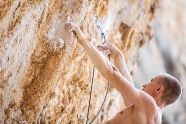 Male rock climber clipping rope — Stock Photo, Image