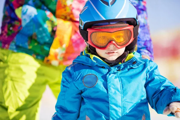 Pouco esquiador usando capacete de esqui e óculos — Fotografia de Stock