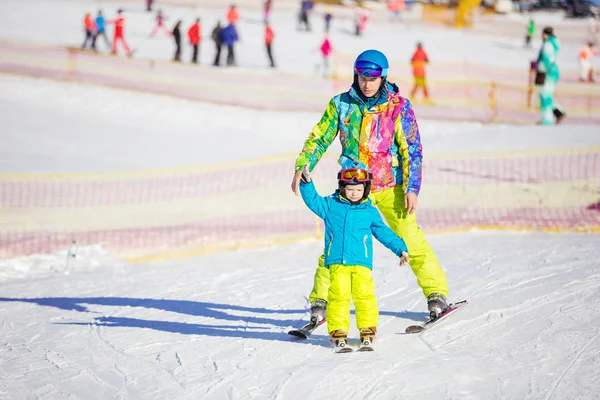 Pai instrutor sênior ensinando menino a esquiar — Fotografia de Stock