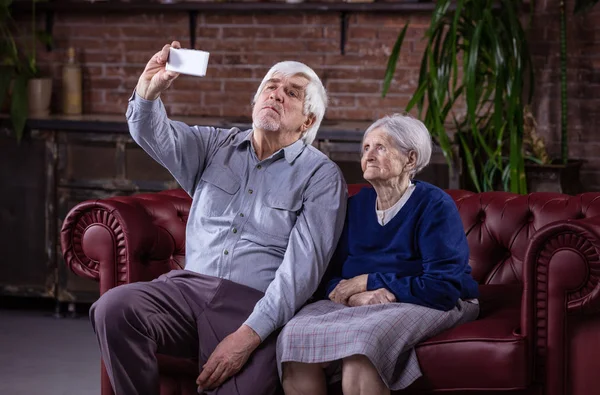 Старшая пара делает селфи со смартфоном — стоковое фото