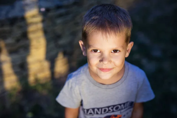 Mignon préscolaire garçon levant les yeux et souriant — Photo