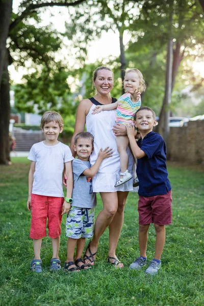 Mladá žena s batole dívka a tři mladí kluci v létě par — Stock fotografie