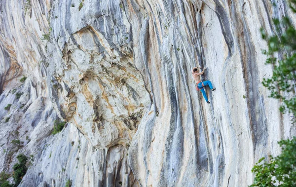 Caucasian young man climbing challenging route on cliff — Stock Photo, Image