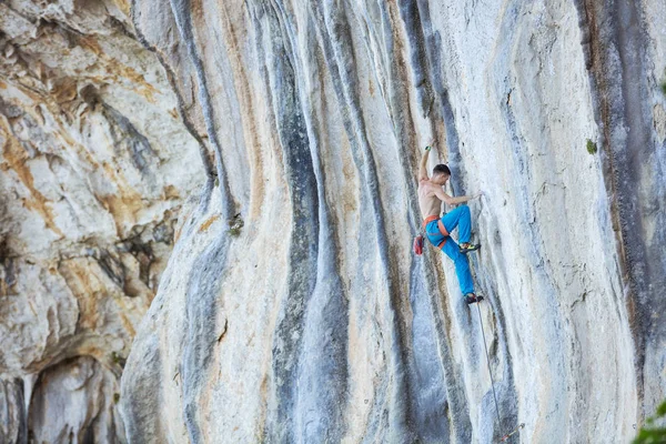 Vit ung man klättrar utmanande rutt på klippan — Stockfoto