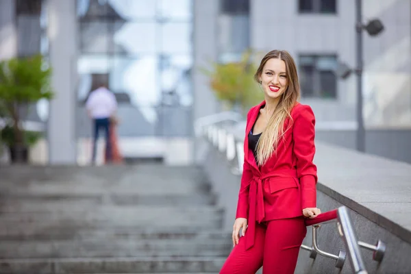 Attractive young woman standing on stairs in business district — Stock Photo, Image