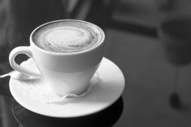 Beyaz kupa kahve ile. Güzel kokulu bir kapuçino. Bir bokeh ile sıradışı bir renkli fotoğraf.