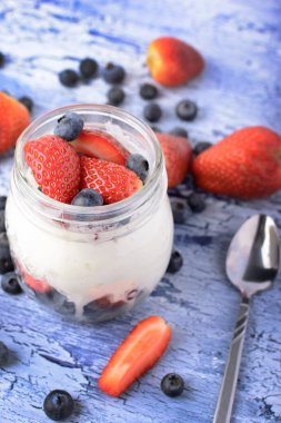 Yaban mersini ve çilek ile lezzetli süt tatlı. Sağlıklı kahvaltı yakın çekim. Yararlı gıda.