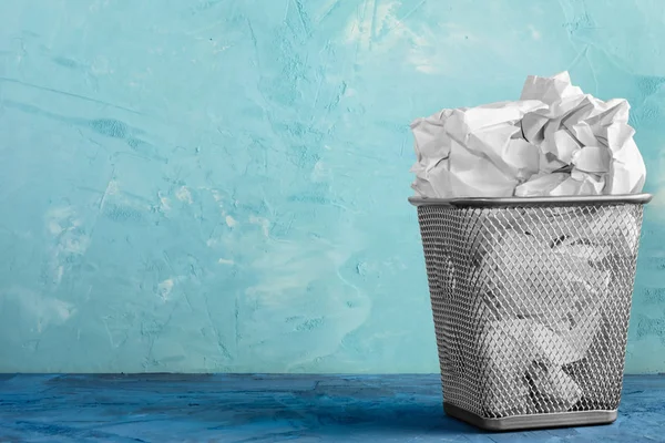 A trash can for paper. Beautiful background with place for text. A full trash can for crumpled paper sheets.