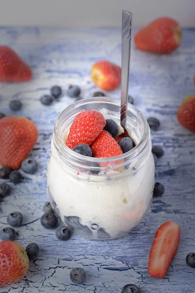 Mleko deser zbliżenie z winiety. Jogurt w słoiku, z truskawek i borówek. Przydatne śniadanie. — Zdjęcie stockowe