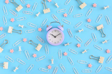 İleti örneği düzensizce mavi bir arka plan üzerinde dağınık. Beyaz ataç, büro düğmeleri ve pembe yıldızlarda küçük bozukluğu. Küçük leylak çalar saat merkezidir. En baştan hayal.