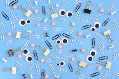 Beyaz Zımba, kukla gözleri ve pembe yıldız rasgele mavi bir arka plan üzerinde dağınık vardır. Komik gülen klipleri merkezi üzerinden. Parlak yukarıdan fotoğrafı.