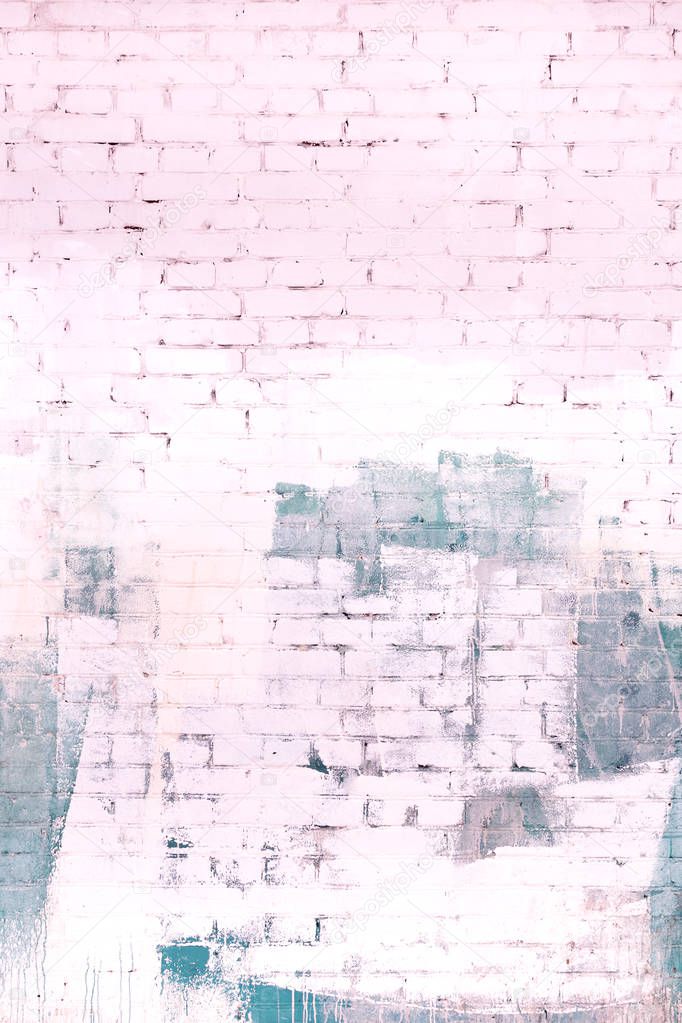 The brick wall is painted in an abstract gray and pale pink paint. Background, texture.