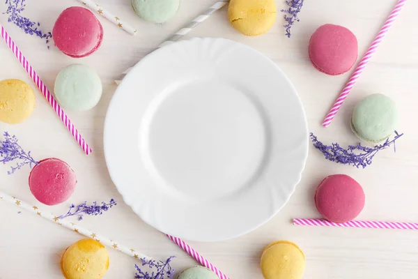 Un plato blanco y vacío, con un delicioso postre alrededor, macarrones y tubos para un cóctel. Lugar para el texto. Disposición festiva, plantilla . — Foto de Stock