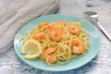 Spagetti karides ve biber karışımı ile lezzetli bir tarif. Güzel mavi tabakta yemek hazır.