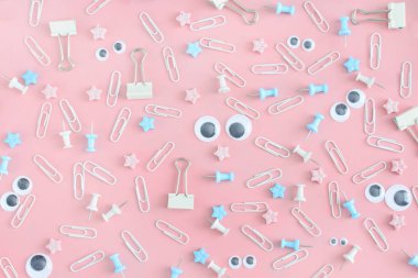 Dağınık ileti örneği ile sıradışı bir resim. Komik suratlar kukla gözleri olan. Klipleri, büro düğmeleri ve bozukluğu pembe bir arka plan üzerinde yıldız.