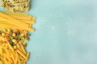 Penne, Mafalde, Tagliatelle, spagetti üzerinde mavi bir arka plan ortaya koydu. Metin için yer ile makarna güzel kompozisyon.