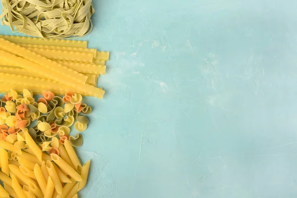 Penne, Mafalde, Tagliatelle, Spaghetti określonymi na niebieskim tle. Piękna kompozycja makaronu z miejsca na tekst. — Zdjęcie stockowe