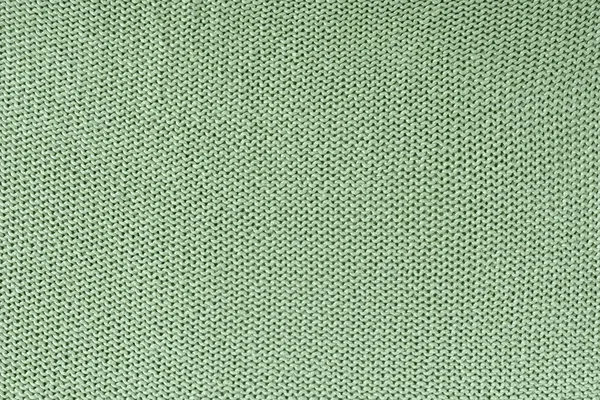 Textura monocromática de tricô. Belo fundo em branco com laços. O produto tricotado é verde . — Fotografia de Stock