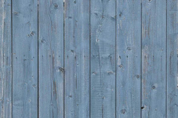 Uma cerca feita de velhas tábuas de madeira com pregos enferrujados. Fundo azul vazio para layouts e sites — Fotografia de Stock