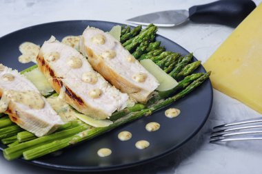 Doğranmış hindi fileto, yeşil kuşkonmaz ve parmesan peyniri. Fıstık soslu lezzetli bir diyet yemeği.