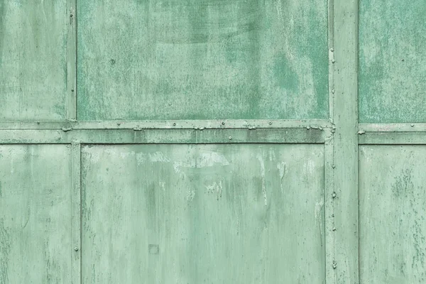 Foto tonica, sfondo verde per siti e layout. Un frammento della struttura protettiva di lamiere con rivetti — Foto Stock
