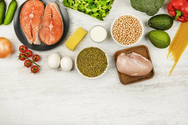 Chickpeas, fish, eggs, cheese and vegetables on a light background, flat lay. The concept of proper nutrition, a flexible diet. Copy space