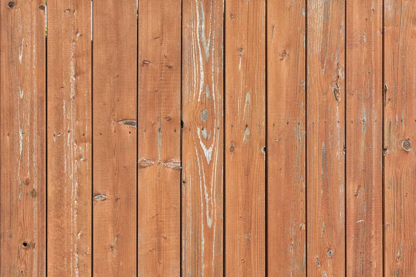 Foto de uma cerca feita de tábuas verticais de madeira. Fundo brilhantemente marrom, para layouts e sites — Fotografia de Stock