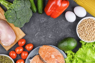 Düzgün beslenme ve diyet kavramı. Sebzeler, tahıllar, balıklar, yumurta ve tavuk siyah arka planda, düz yatak. Merkezde boşluk kopyala