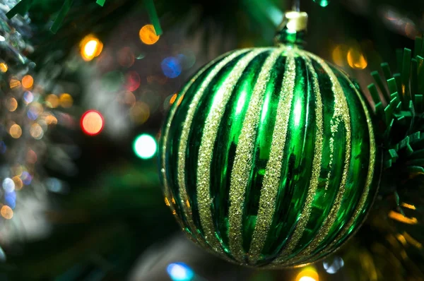 green christmas ball on a spruce branch