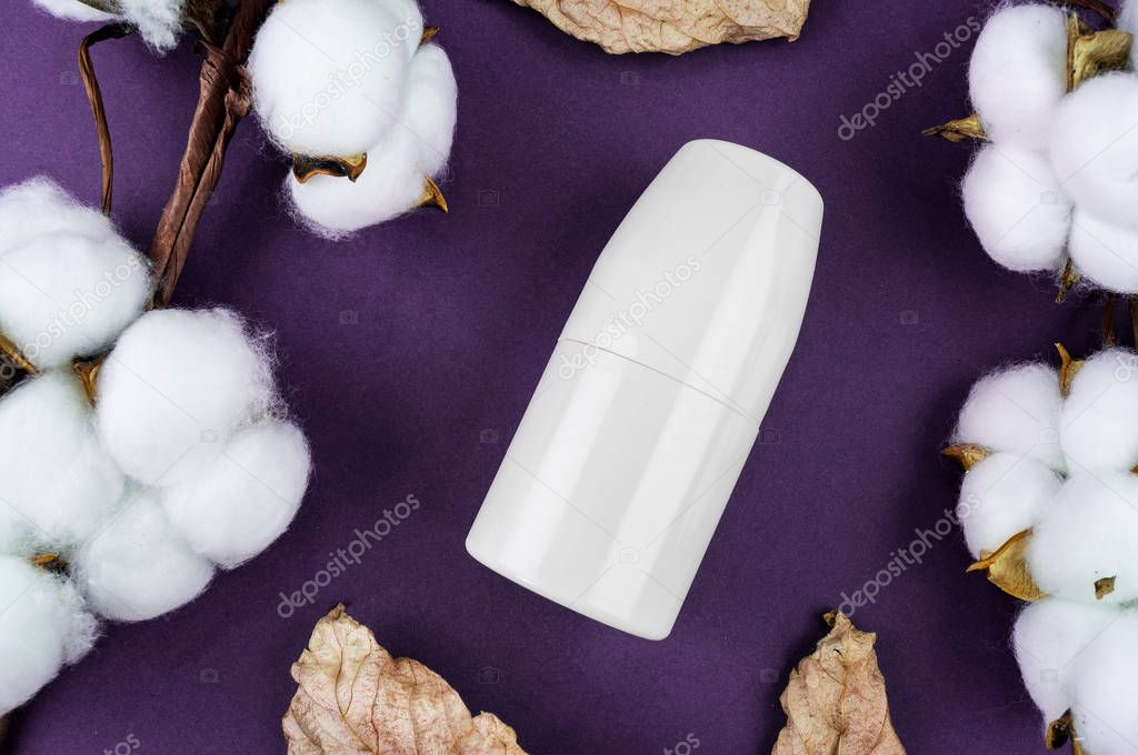 Mockup antiperspirant on a purple background. Cotton and leaves are natural cosmetics.