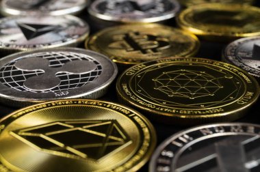 A lot of cryptocurrency coins lie on a dark surface clipart
