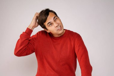 Kırmızı kazaklı adam düşünüyor. Beyaz arkaplandaki resim