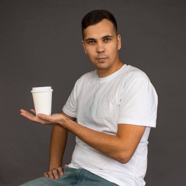 Beyaz tişörtlü adam kahve öneriyor..