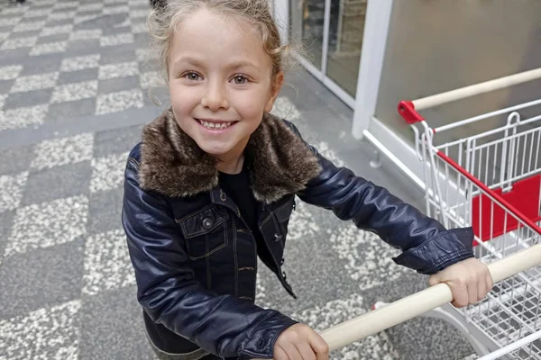 Aranyos kislány boldog a bevásárló kosár. — Stock Fotó