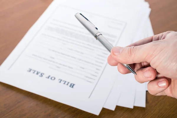 Man's hand with a pen gives the pen for signing a contract Stock Photo