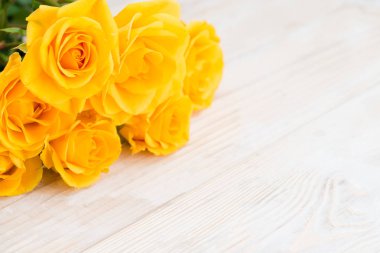 Sarı çalı gül Beyaz ahşap bir masa için desen üzerinde 