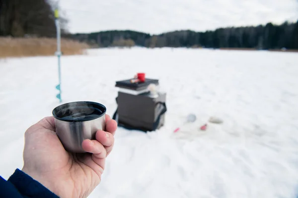 Chá quente na mão do pescador, um piquenique na pesca no gelo — Fotografia de Stock