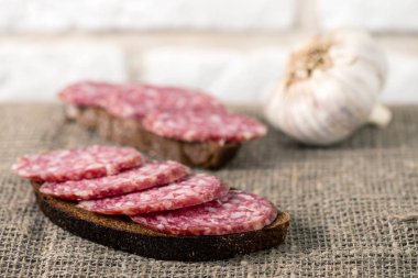çuval bezi ekmek ile dilimlenmiş salam sosis