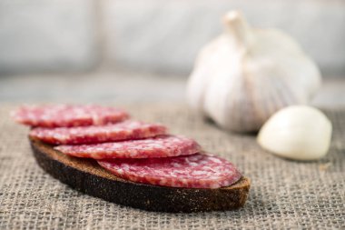 çuval bezi ekmek ile dilimlenmiş salam sosis