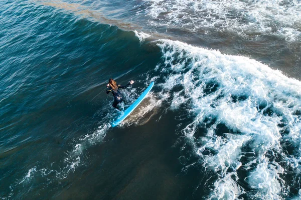 Surfer at the top of the wave, top view aerial shooting surfing