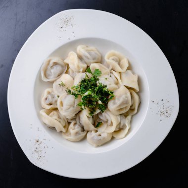 Bir tabak sıcak Rus eti hamur köftelerini beyaz tabakta kaynattı.