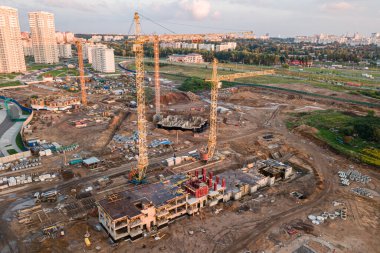 Vinçleri olan bir inşaat alanı. İnşaat işçileri inşa ediyor. Turnalı konut binalarının inşaat alanının havadan görüntüsü