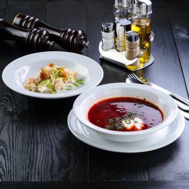 Masada iki tabak var. Geleneksel Rus Borsch 'uyla öğle yemeği. Ahşap masa üzerinde pancar çorbası çorbası..